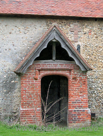 Dedication Unknown, Mashbury Church - This tudor brick porch was built approx 1500. The roof of both 
this porch, and the nave are C15.
Note the obsured Norman window, and the cross shape, formed 
from tiles.
